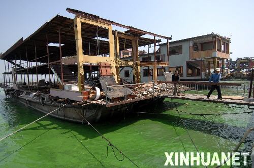 这是2007年8月23日,工人在拆除搭建在太湖中的无锡太湖马山水上餐厅建筑群。位于太湖之滨的江苏省无锡市有“太湖明珠”之称。2007年春天,太湖蓝藻暴发让这座城市200万市民经历了持续约一周的饮水危机。痛定思痛,无锡市除完善城乡污水处理系统、减少湖面养殖、再造湖滨湿地等措施外,城区内所有规模以下的“五小”企业(小钢铁、小水泥、小化工、小电镀、小印染)一律关闭,同时大力整治“三高两低”(高消耗、高污染、高危险、低产出、低效益)企业。