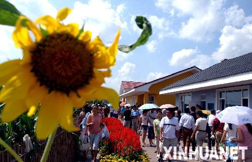 2003年8月17日,观众在第四届中国长春国际农业·食品博览(交易)会上参观小康住宅区。在本届长春农博会上,四栋新颖别致、健康环保的住宅成为众多农民关注的热点。设计者将其命名为乡村新住宅,也称作小康住宅。小康住宅在原有乡村住宅基础上改建为庭院格式,增加了蔬菜大棚、沼气池、猪舍、厕所“四位一体”的能源生态模式工程,为农民展现了一种可持续发展的居住新模式,为建设农村经济型、生态型住宅提供参考