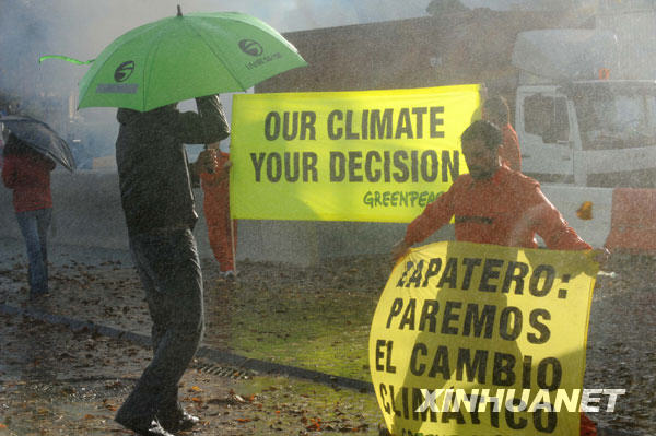 11月5日，在西班牙巴塞罗那举行的2009年联合国第五次气候变化谈判的会场外，绿色和平组织成员模拟“风雨交加”的恶劣天气效果，揭示气候变化给人类生存环境带来的灾难性破坏，呼吁发达国家为解决气候变化问题迅速采取实际行动。当日，2009年联合国第五次气候变化谈判在巴塞罗那继续进行。