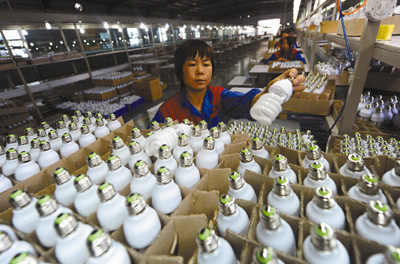 河南三门峡市鹏飞电子公司的工人正在生产节能灯。
