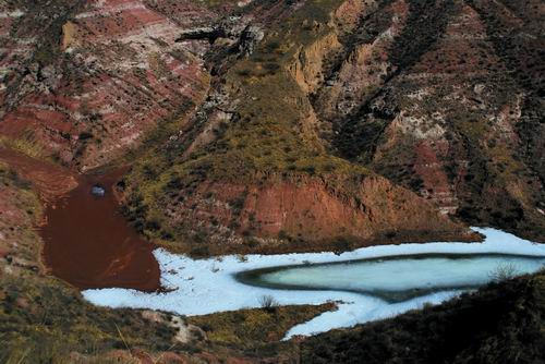 5.砒砂岩侵蚀区面貌,红色为雨水冲击后形成的沙地,白色为结冰的微型水库上游。